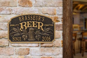 Bronze plaque displaying 'Brasseur's Beer' with decorative elements and the year 2016.