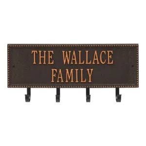 Bronze wall plaque with the text 'The Wallace Family' and four hooks for hanging items.