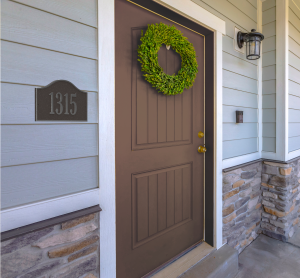 Brown door with a green wreath and a small plaque displaying the number 1315.